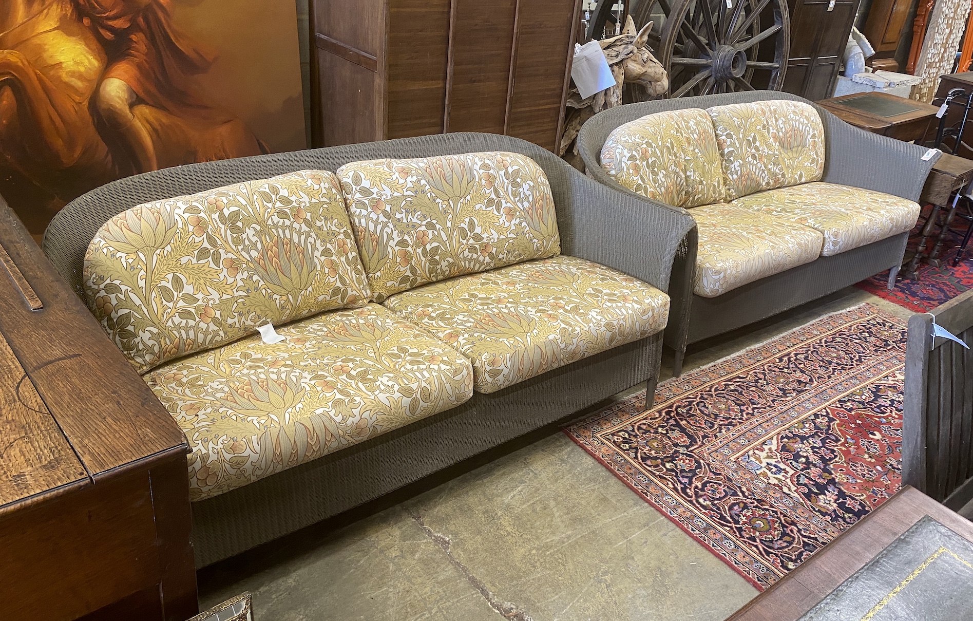 A pair of Lloyd Loom garden settees with William Morris fabric cushions, width 187cm, depth 74cm, height 81cm